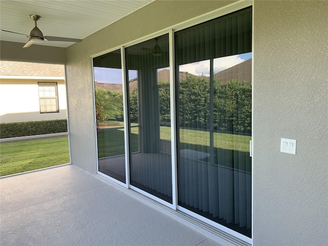 unfurnished sunroom with ceiling fan