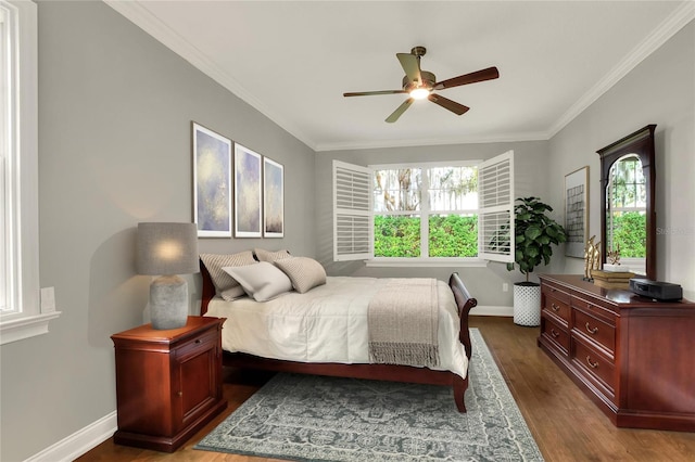 bedroom featuring ceiling fan, wood-type flooring, multiple windows, and ornamental molding