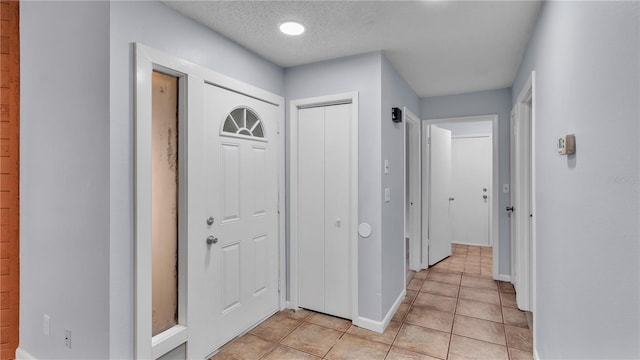 tiled entrance foyer with a textured ceiling