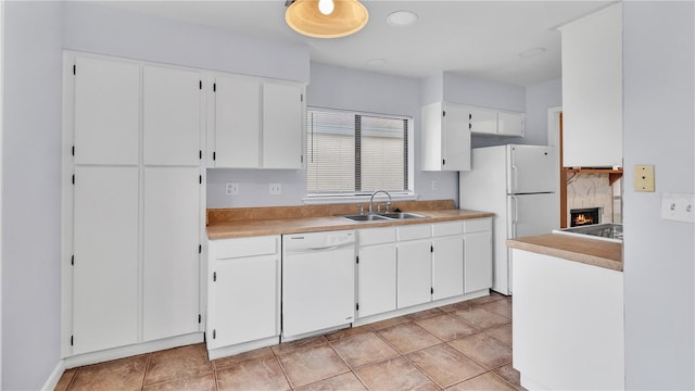 kitchen featuring a high end fireplace, white appliances, white cabinetry, and sink