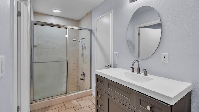 bathroom featuring vanity, tile floors, and a shower with door