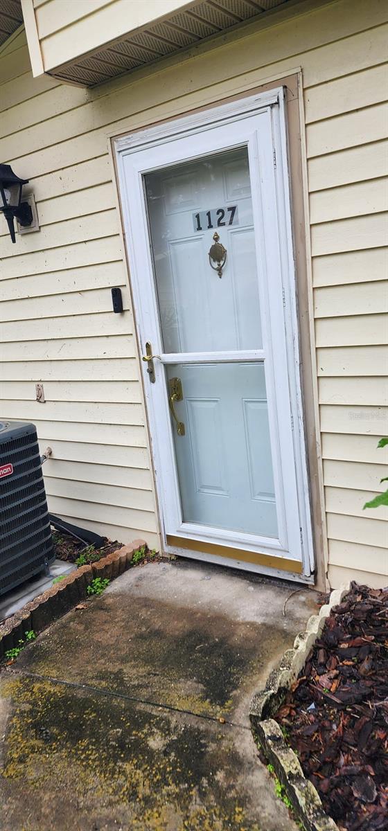 property entrance featuring central AC unit