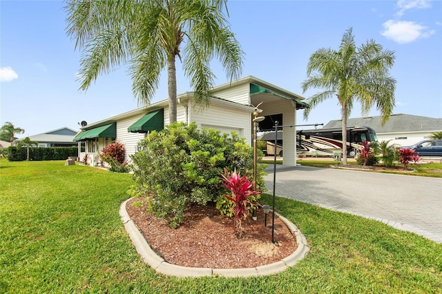 view of front of home with a front yard and a carport