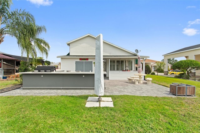 rear view of house featuring a lawn and a patio