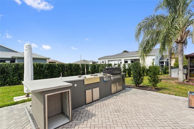 view of terrace with a grill, an outdoor kitchen, and a shed