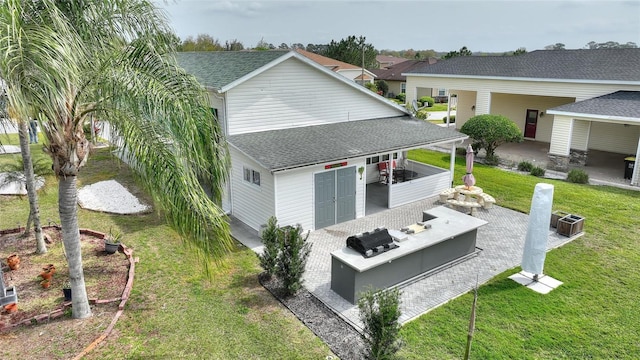 back of property featuring a lawn, outdoor lounge area, a patio area, and exterior kitchen