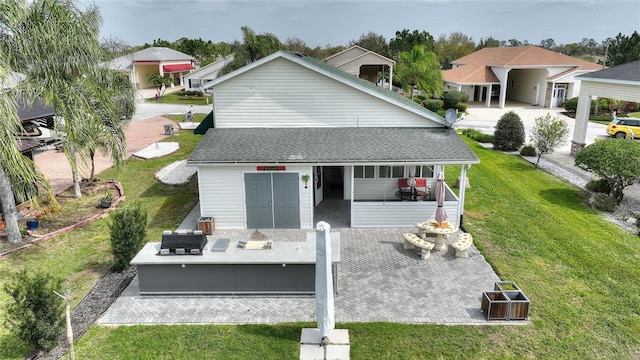 rear view of property with a patio area, an outdoor living space, and a yard