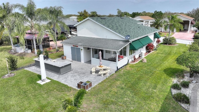 back of property with a lawn and a patio area