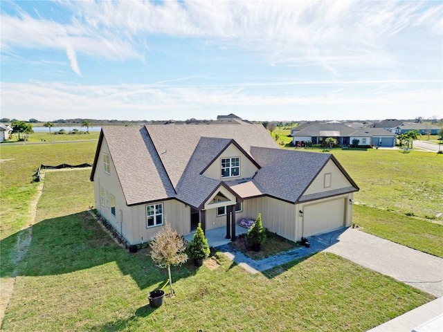 view of front of house featuring a water view, a garage, and a front lawn