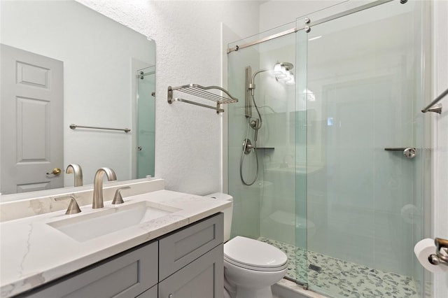 bathroom featuring toilet, an enclosed shower, and vanity