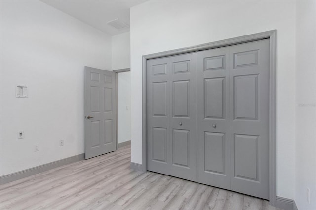 unfurnished bedroom featuring light hardwood / wood-style floors and a closet