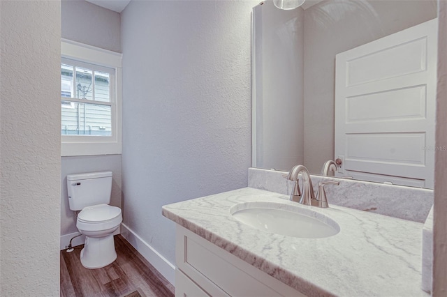 bathroom featuring hardwood / wood-style flooring, large vanity, and toilet