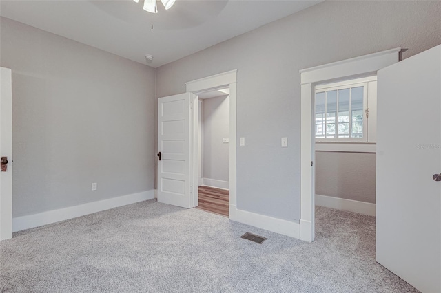 unfurnished bedroom with light colored carpet and ceiling fan