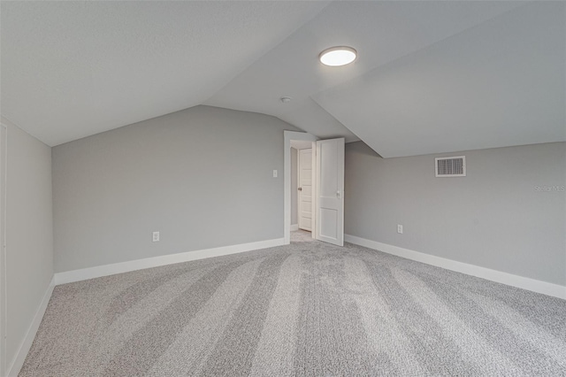 bonus room with light carpet and lofted ceiling