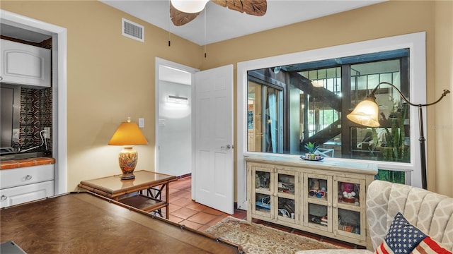 living area featuring ceiling fan and light tile floors