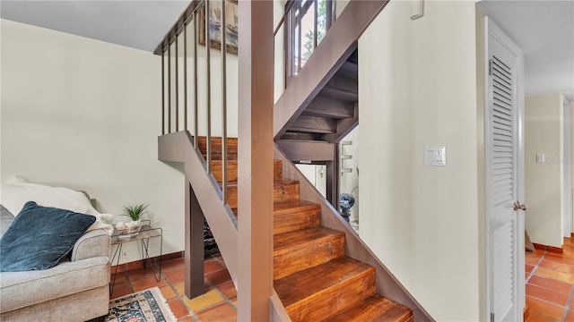 staircase with dark tile floors