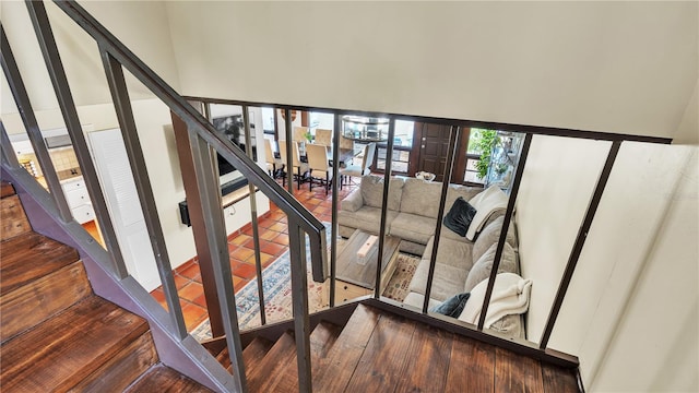 stairs with dark hardwood / wood-style floors and a towering ceiling