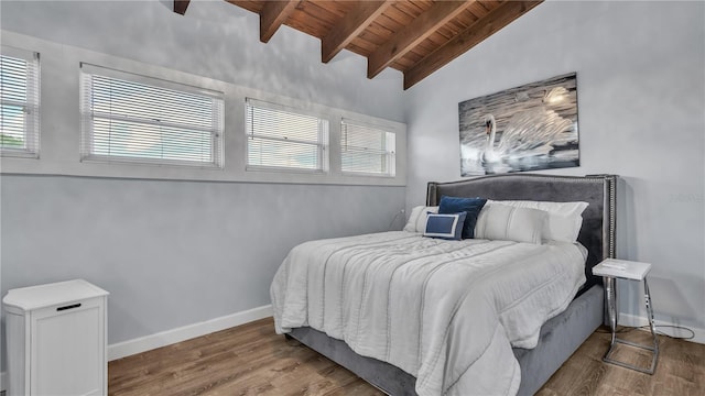 bedroom featuring ceiling fan, lofted ceiling with beams, wood ceiling, and hardwood / wood-style flooring