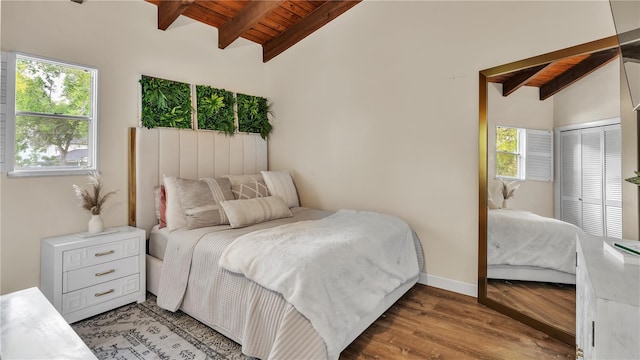 bedroom featuring wood ceiling, vaulted ceiling with beams, multiple windows, and hardwood / wood-style flooring