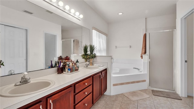 bathroom with double vanity, tile flooring, and separate shower and tub