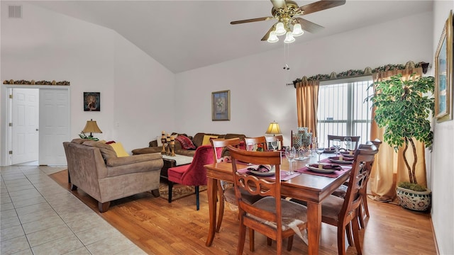 dining space with light tile floors, ceiling fan, and high vaulted ceiling