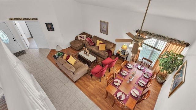 living room with light tile flooring, ceiling fan, and high vaulted ceiling