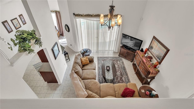 tiled living room featuring a chandelier and a high ceiling