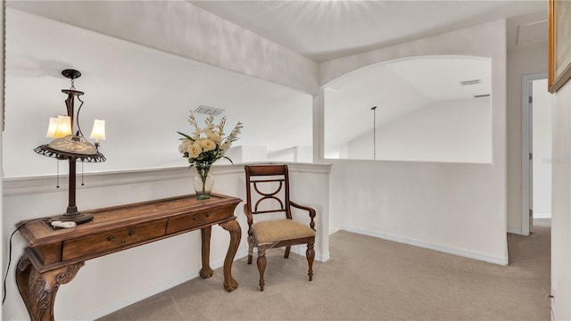 sitting room featuring a notable chandelier, vaulted ceiling, and light colored carpet