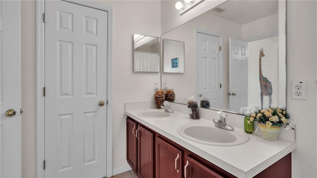 bathroom with dual sinks and vanity with extensive cabinet space