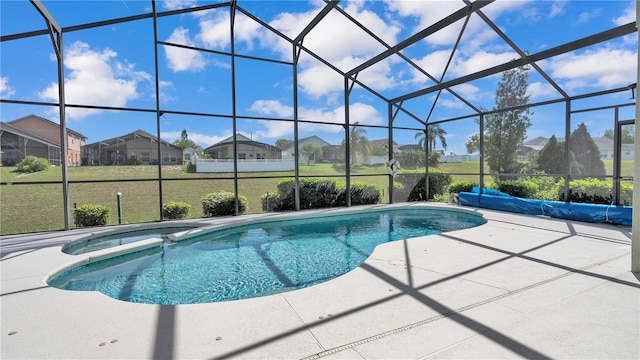 view of swimming pool with a yard, glass enclosure, and a patio