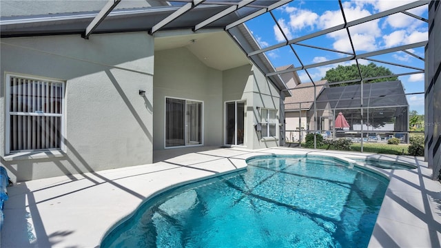 view of swimming pool with glass enclosure and a patio area