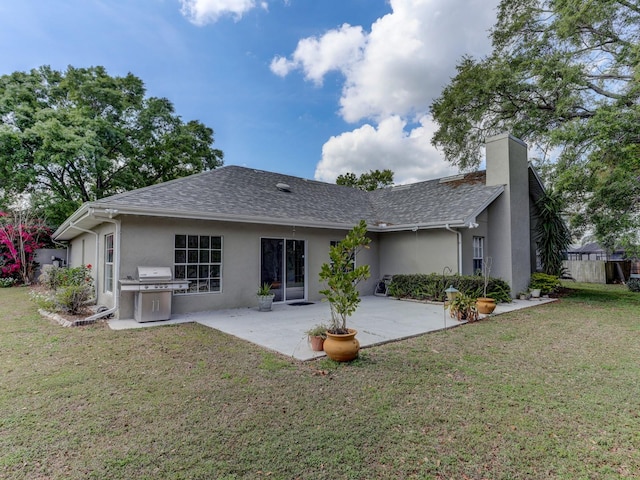 back of property featuring a lawn and a patio area