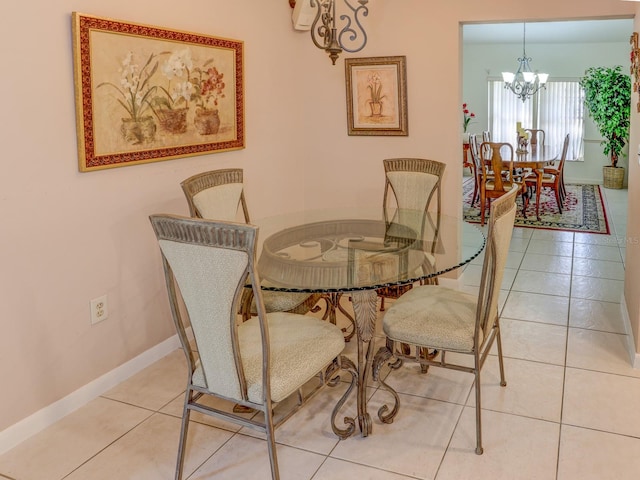 dining area with a notable chandelier and light tile floors