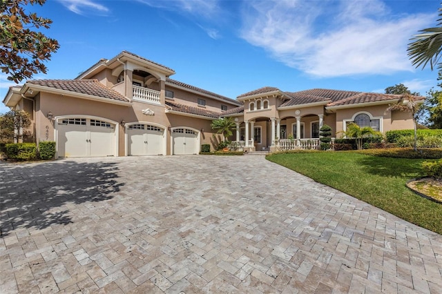 mediterranean / spanish-style home featuring a balcony, a front yard, and a garage