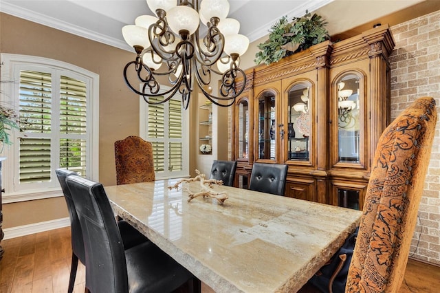 dining space with a notable chandelier, dark hardwood / wood-style flooring, and ornamental molding