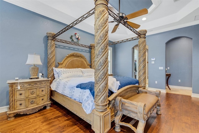 bedroom with a tray ceiling, ceiling fan, and dark hardwood / wood-style floors