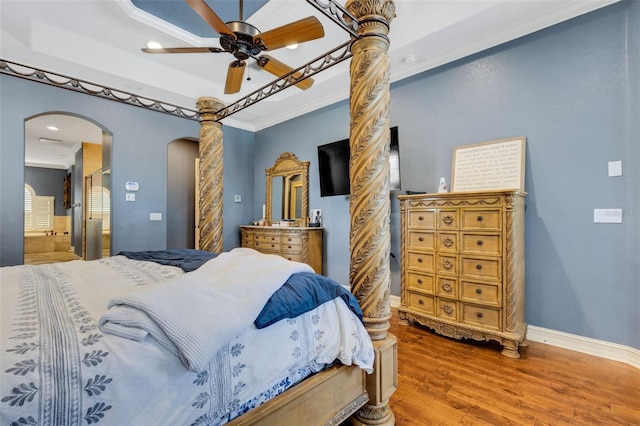 bedroom with a raised ceiling, ornamental molding, ceiling fan, and dark hardwood / wood-style floors