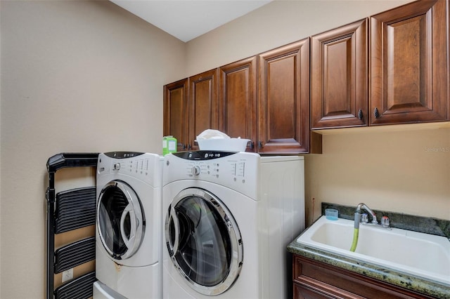 clothes washing area featuring independent washer and dryer, cabinets, and sink