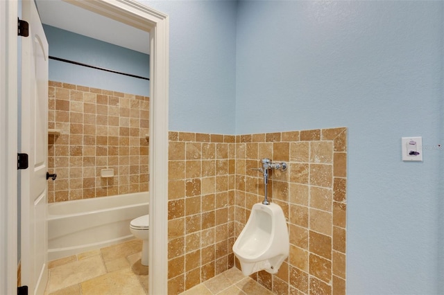 bathroom featuring tile flooring, toilet, and tiled shower / bath