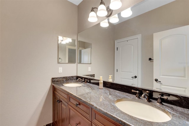 bathroom with an inviting chandelier, dual sinks, and vanity with extensive cabinet space