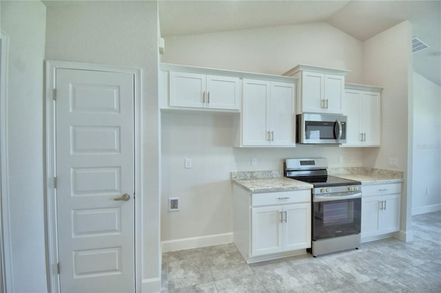 kitchen featuring appliances with stainless steel finishes, vaulted ceiling, and white cabinetry