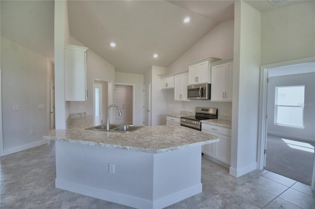 kitchen with kitchen peninsula, appliances with stainless steel finishes, sink, white cabinetry, and light tile patterned flooring