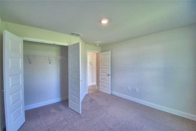 unfurnished bedroom featuring carpet and a closet