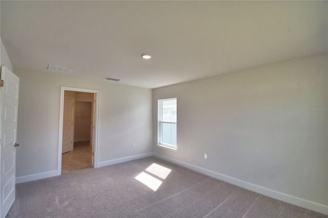 spare room featuring light carpet