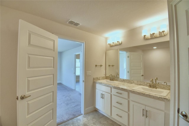 bathroom with a textured ceiling and vanity