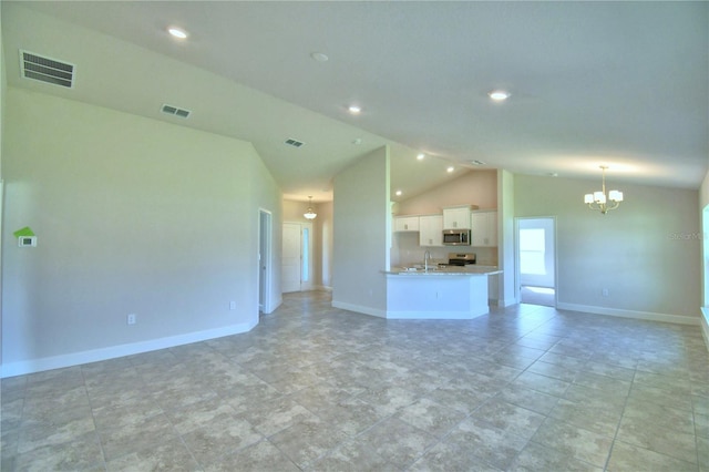 unfurnished living room featuring a notable chandelier, light tile patterned flooring, and lofted ceiling