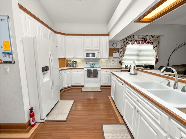 kitchen featuring sink, white appliances, dark hardwood / wood-style floors, and white cabinetry