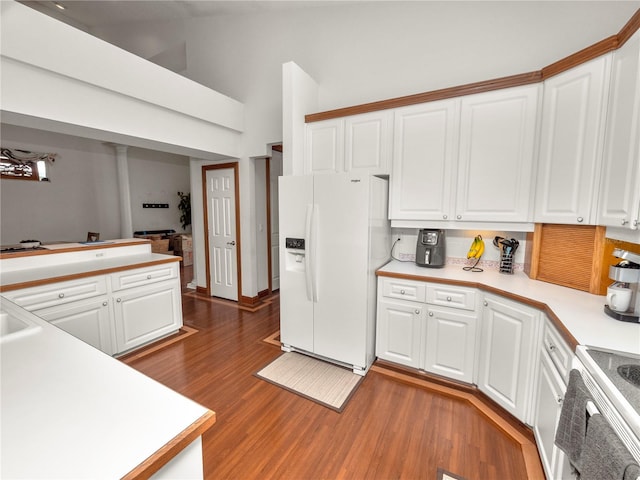 kitchen featuring white appliances, dark wood-type flooring, and white cabinetry