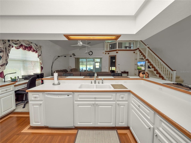 kitchen with white cabinetry, kitchen peninsula, light wood-type flooring, sink, and white dishwasher