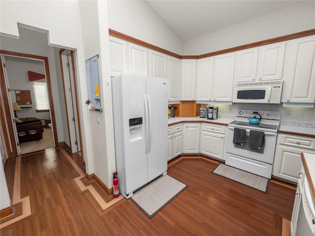 kitchen with lofted ceiling, white appliances, dark wood-type flooring, and white cabinets